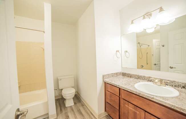 Renovated Bathroom with granite counter tops and wood flooring at Westwind Townhomes in Lansing, Michigan