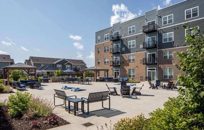 A sunny day at a residential complex with a large open area featuring a table and chairs.
