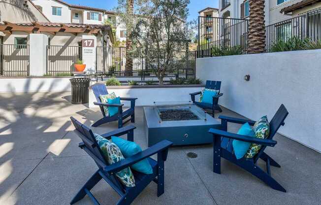 A patio with blue chairs and a table with a tray of fruit on it.