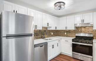a kitchen with stainless steel appliances and white cabinets