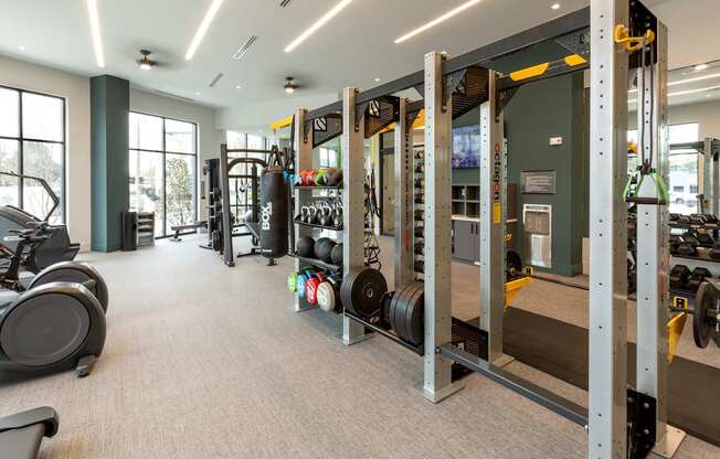 a gym with weights and other equipment in a building with windows