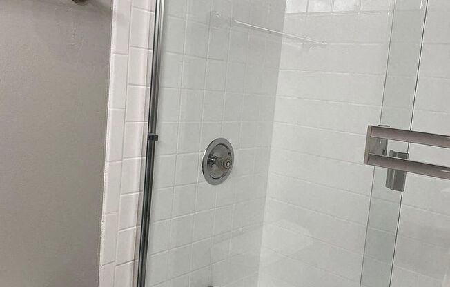 a white bathroom with a shower and a toilet