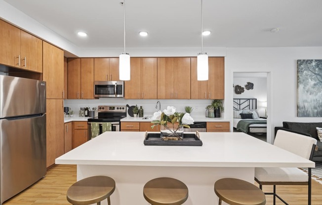 The Edge Milpitas CA a kitchen with wooden cabinets and a white island with four stools