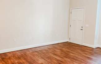 an empty living room with wood floors and a ceiling fan