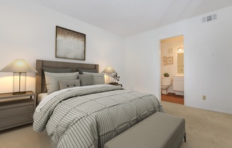 a bedroom with a bed and desk in a room