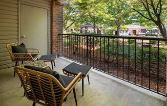 A patio with a table and chairs overlooking a yard.