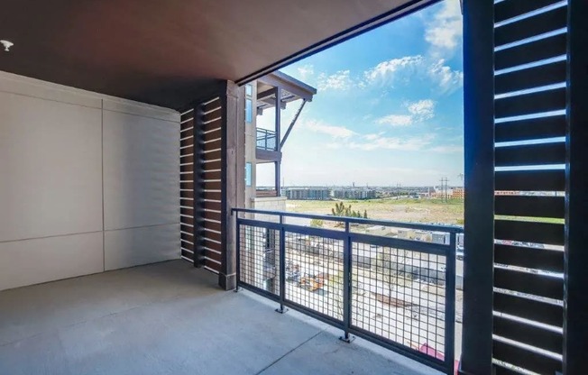 a balcony with a view of a field and a building