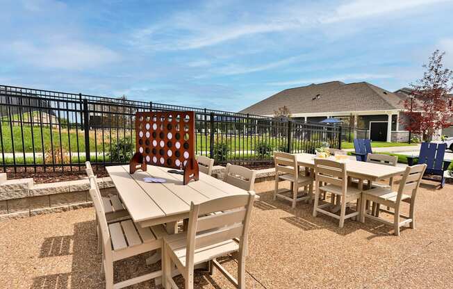 a patio with tables and chairs and a house in the background  at Aventura at Hawk Ridge, Missouri