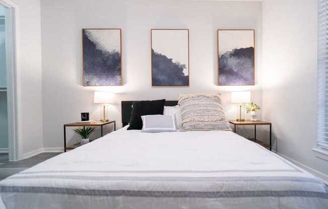 a bedroom with a bed and paintings on the wall