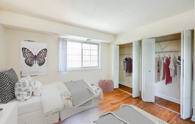 bedroom with two full sized beds, hardwood flooring, window and large closets at naylor overlook apartments in washington dc