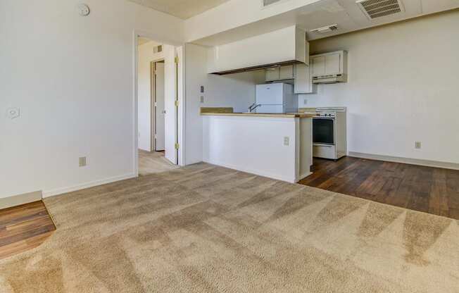 the living room and kitchen of an empty apartment