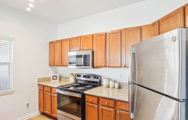 A kitchen with a stove, oven, microwave, and refrigerator.