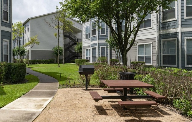 a picnic area with a picnic table in front of an apartment building