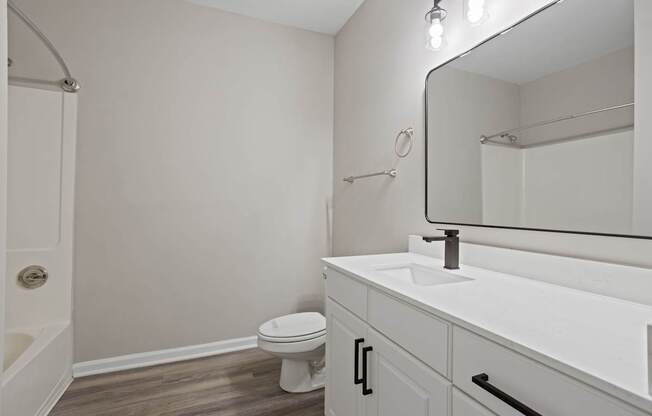 Flatiron West Trade Bathroom with Quartz sinktops and luxury vinyl tile flooring