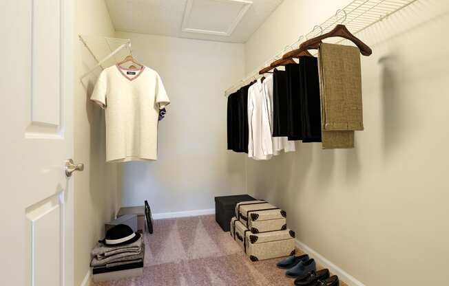 a walk in closet with clothes hanging on the wall and shoes on the floor