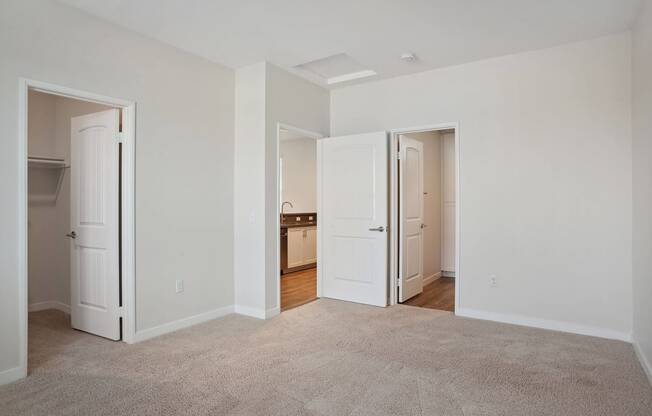 a bedroom with two doors and a carpeted floor at Arrive at Rancho Belago, Moreno Valley