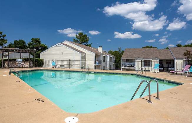 A swimming pool with a slide and a house in the background.