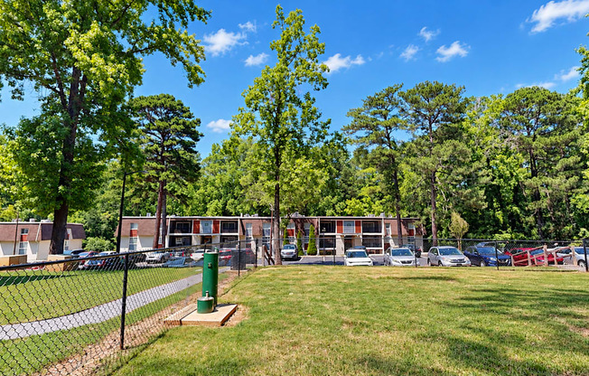 Fenced grassy dog park with a pet waste station at Icon Avondale Apartments in Decatur, GA.