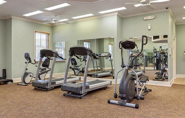 a gym with various exercise bikes and weights at Bedford Parke Apartments, Georgia, 31088