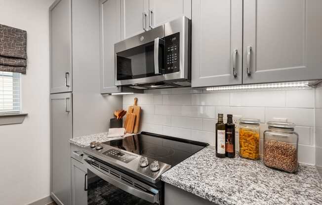 a kitchen with white cabinets and a stove and a microwave