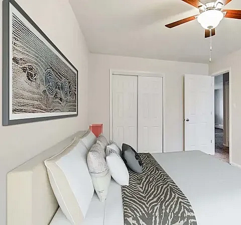 Bedroom at Sunridge Apartment Homes in Englewood, CO, with ceiling fan and natural light