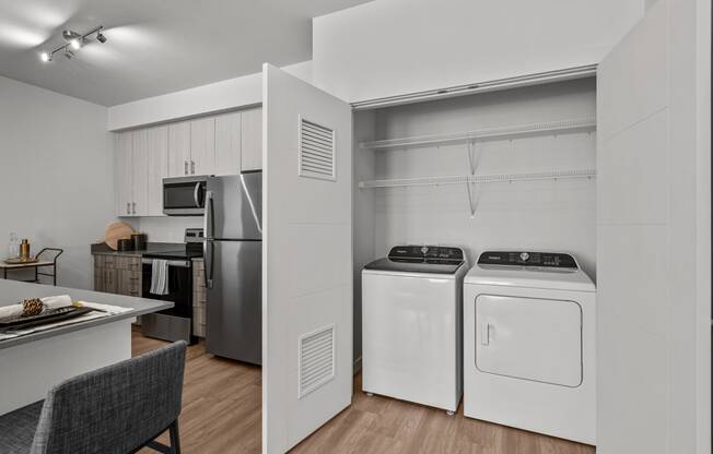 a kitchen with white appliances and a laundry room with stainless steel appliances