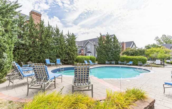 a swimming pool with blue chairs and chairs around it