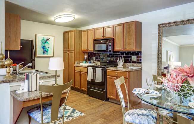 A kitchen with wooden cabinets and a black refrigerator.