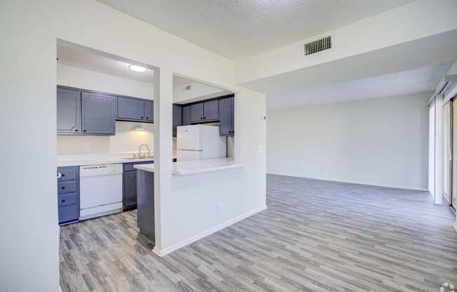 an open kitchen and living room with white and blue cabinets
