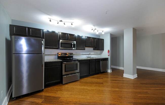 A kitchen with a refrigerator, oven, and microwave.