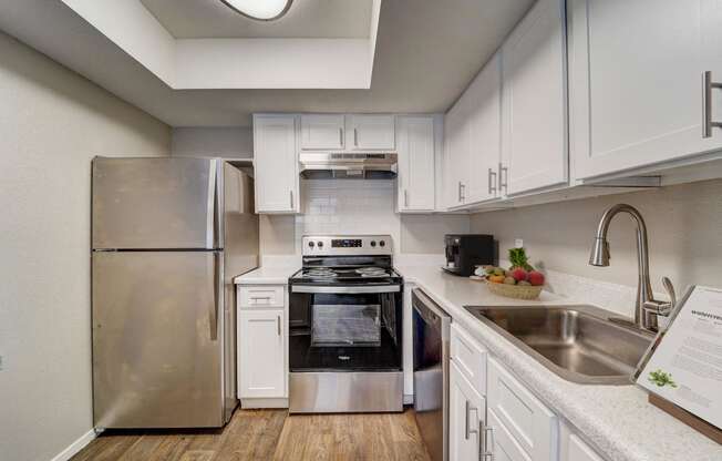 a kitchen with stainless steel appliances and white cabinets