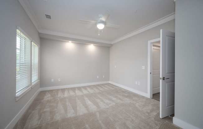 an empty bedroom with a ceiling fan