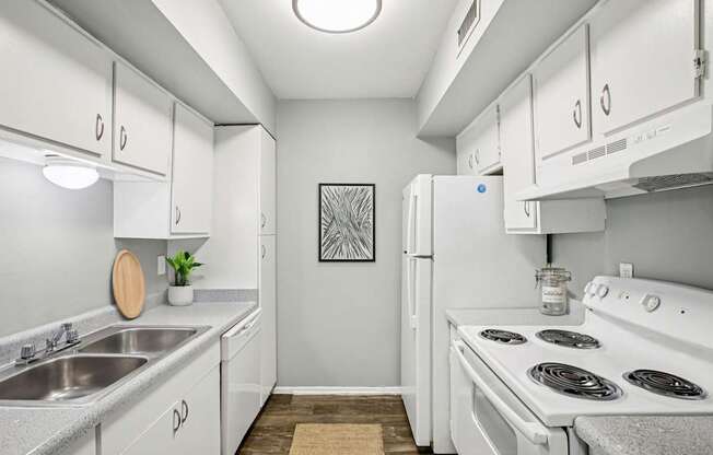 A kitchen with white appliances and cabinets.