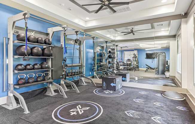 A gym with a variety of equipment including kettlebells and weightlifting machines.