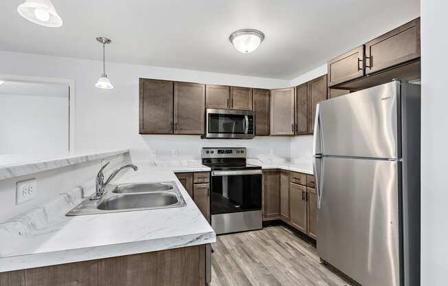 a kitchen with wooden cabinets and stainless steel appliances