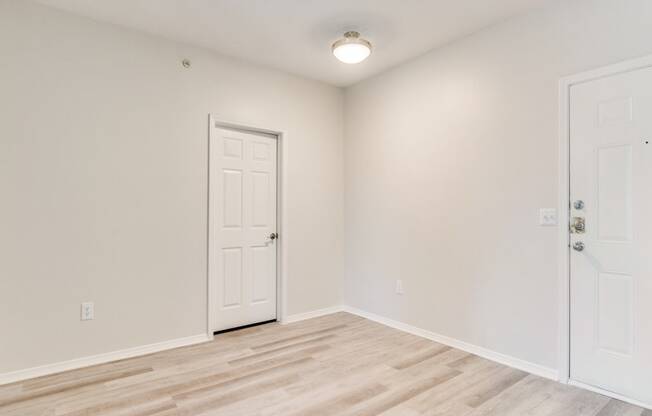 a bedroom with hardwood floors and white walls at Arioso apartments located at 3030 Claremont Dr in Grand Prairie, TX