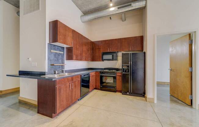 A kitchen with a black counter top and brown cabinets.