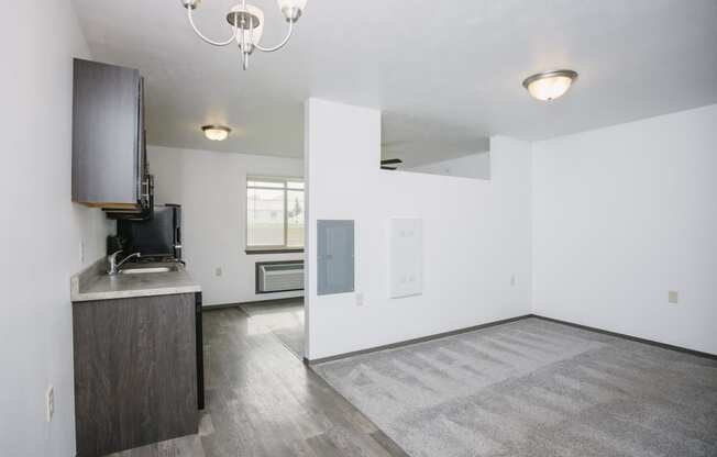 the living room and kitchen in a new home with white walls and wood flooring