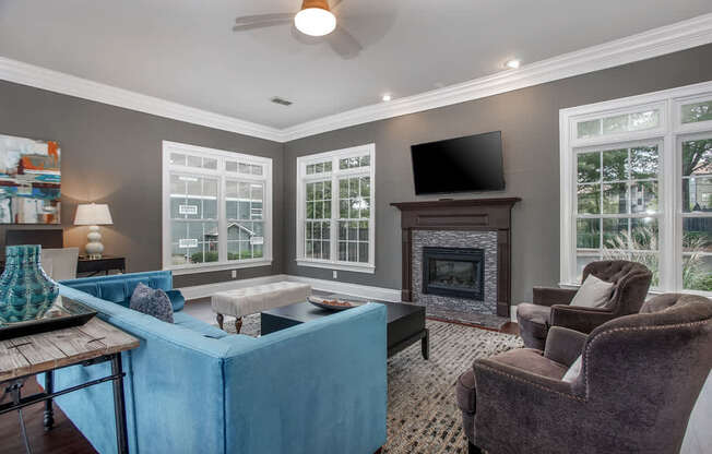 A living room with a blue couch and a fireplace.