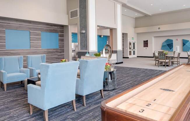 a room with a shuffleboard table and blue chairs