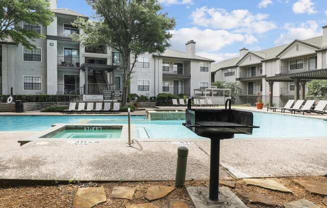 a swimming pool and a grill at Jefferson Creek in Irving, TX