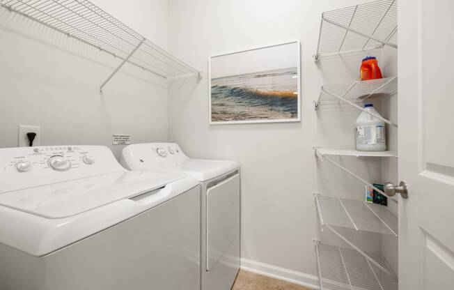 a white washer and dryer in a laundry room with a white closet