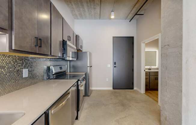 a renovated kitchen with stainless steel appliances and a door to a hallway