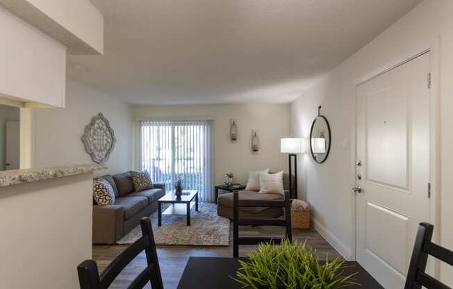 This is a photo of the living room from the dining area of the 515 square foot 1 bedroom apartment at Canyon Creek Apartments in Dallas, TX