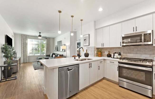 A modern kitchen with white cabinets and stainless steel appliances.