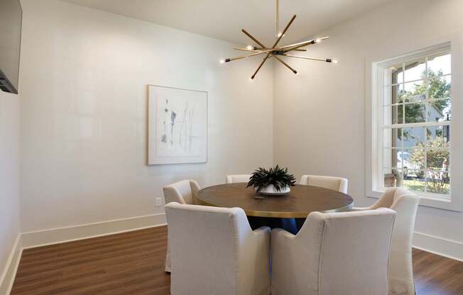 A dining room with a round table and chairs.