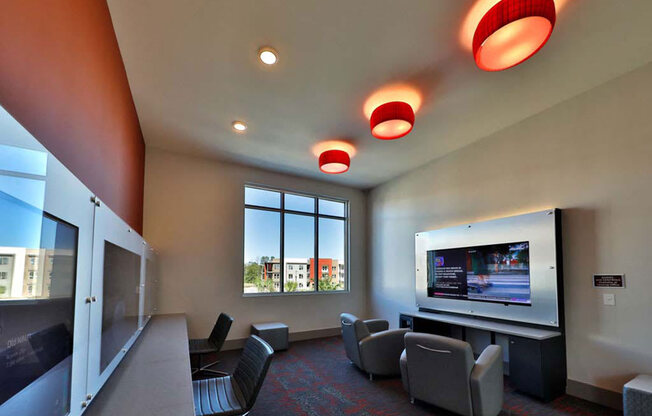 a room with a television and chairs in it at Luxor Club, Florida