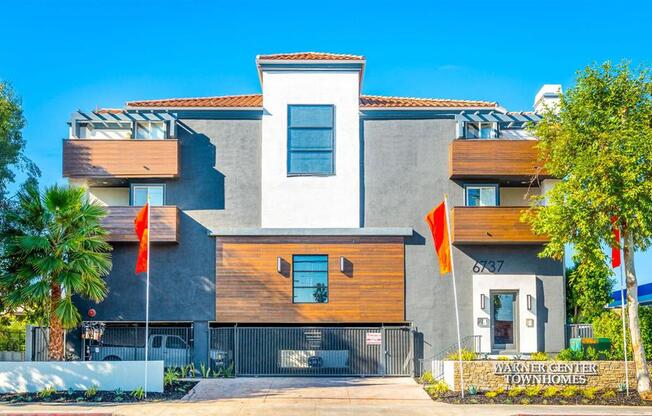 a house with two orange flags in front of it at Warner Center Townhomes, Canoga Park 