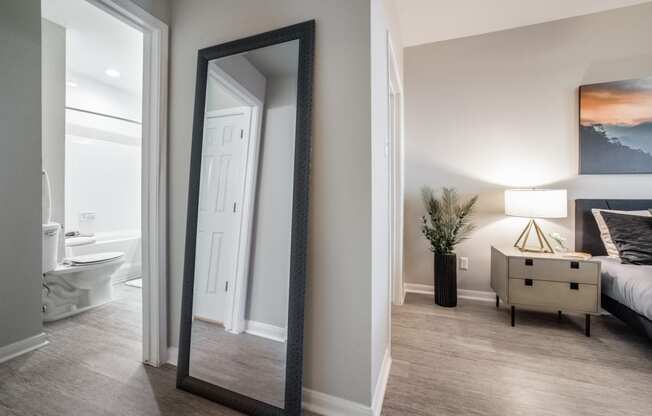 a mirror in a bedroom with a bed and a bathroom