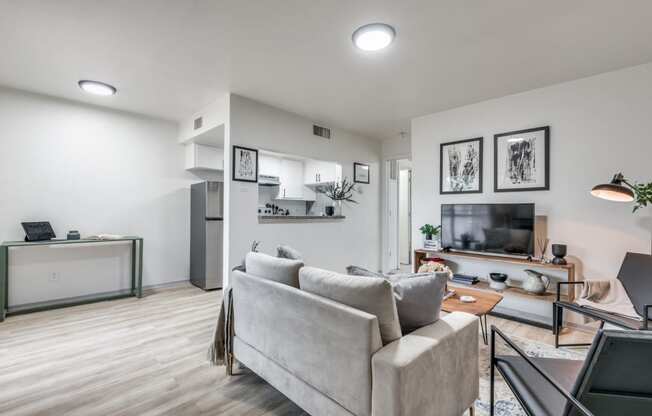 a living room with white walls and hardwood floors